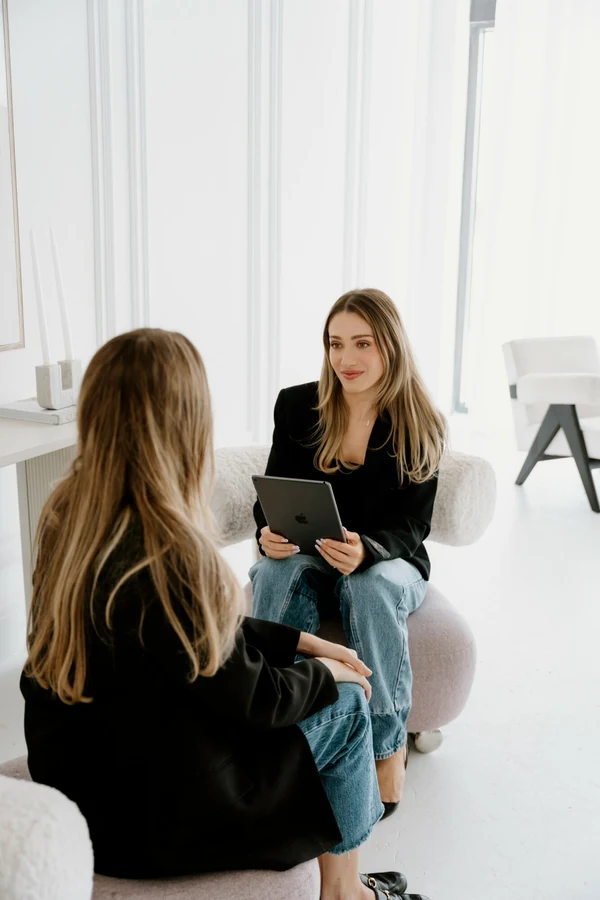 Hayden holding a tablet in conversation, from her VoyageMIA feature.