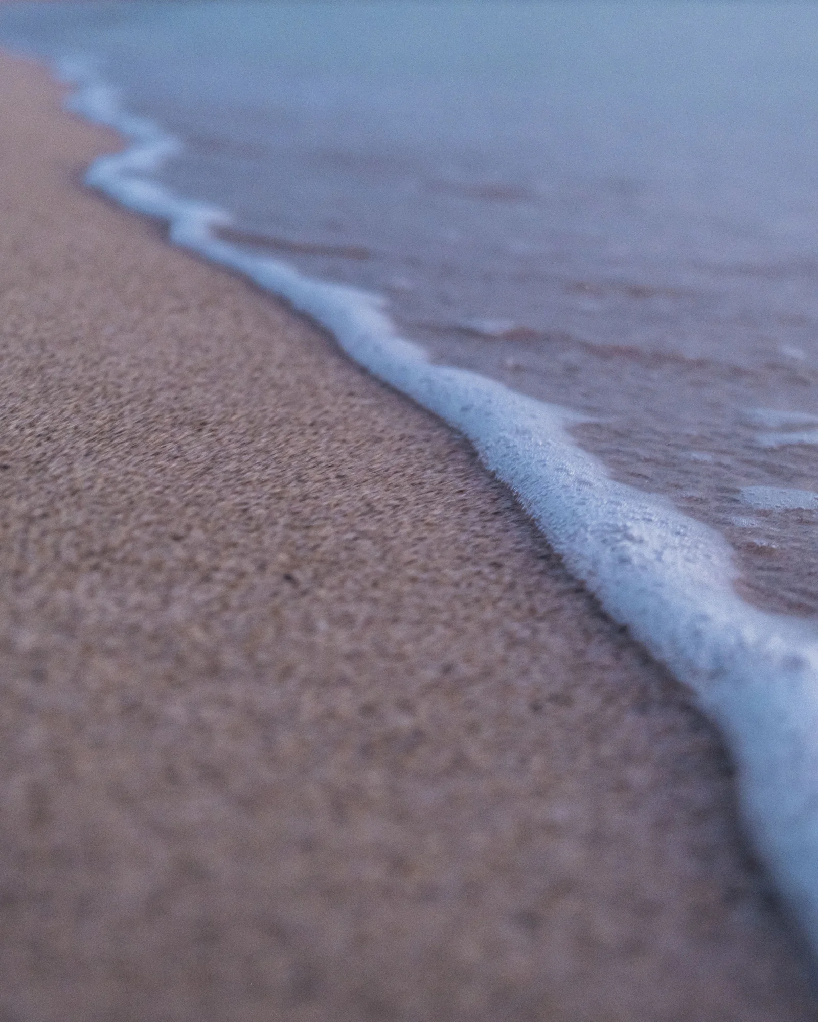 Soft blue shoreline meeting warm sand
